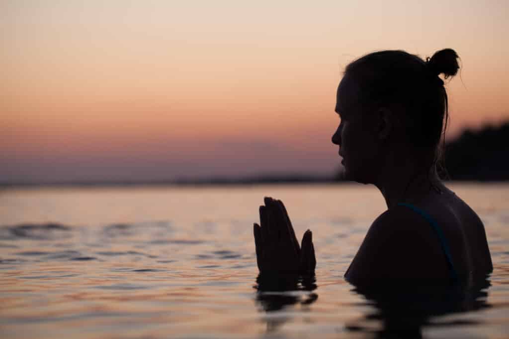 Woman in water praying or meditating 403189